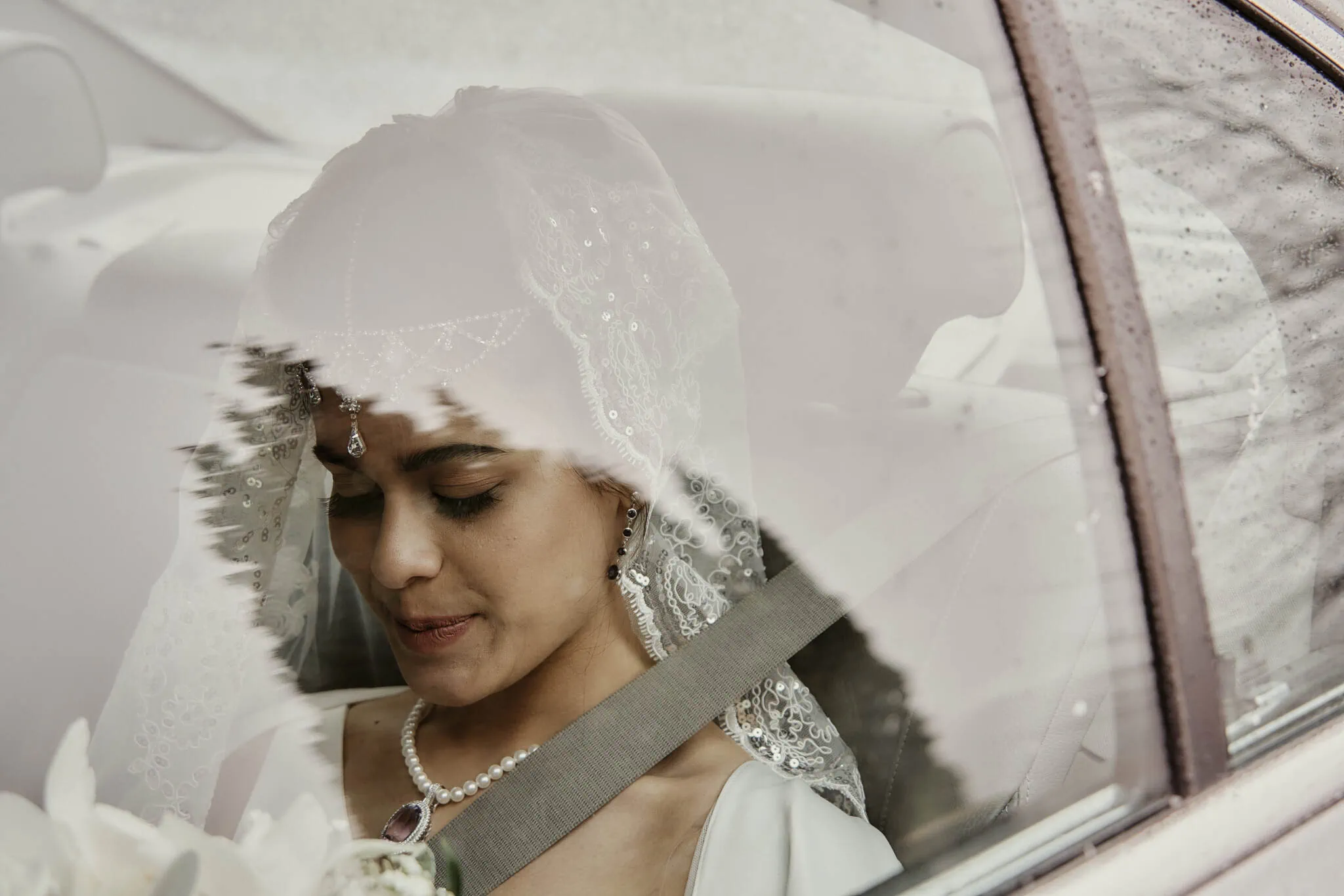Queenstown New Zealand Elopement Wedding Photographer - A Queenstown Islamic bride is sitting in the back seat of a car.
