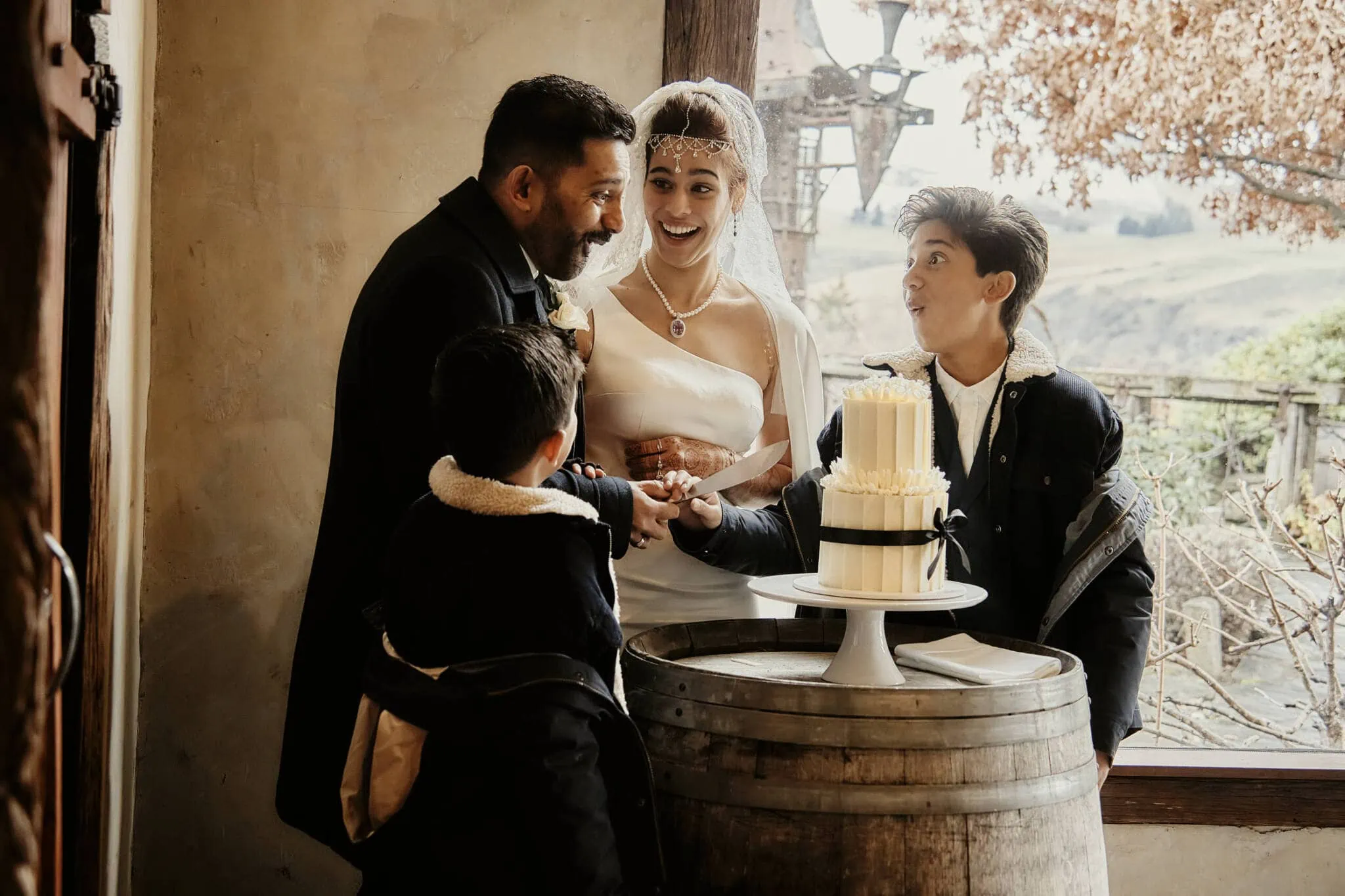 Queenstown New Zealand Elopement Wedding Photographer - Wasim and Yumn cutting their Islamic wedding cake in front of a barrel in Queenstown.