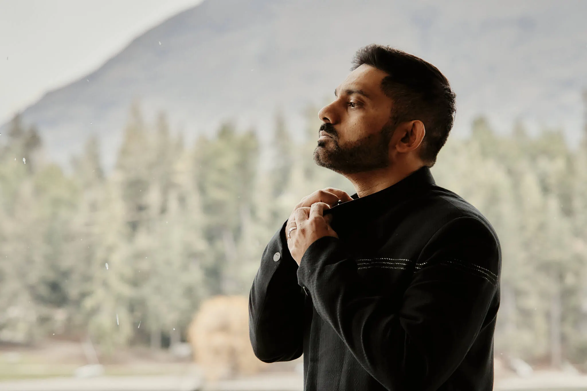 Queenstown New Zealand Elopement Wedding Photographer - Wasim and Yumn celebrate their Islamic wedding in Queenstown with a breathtaking view of a man standing in front of a lake with mountains in the background.