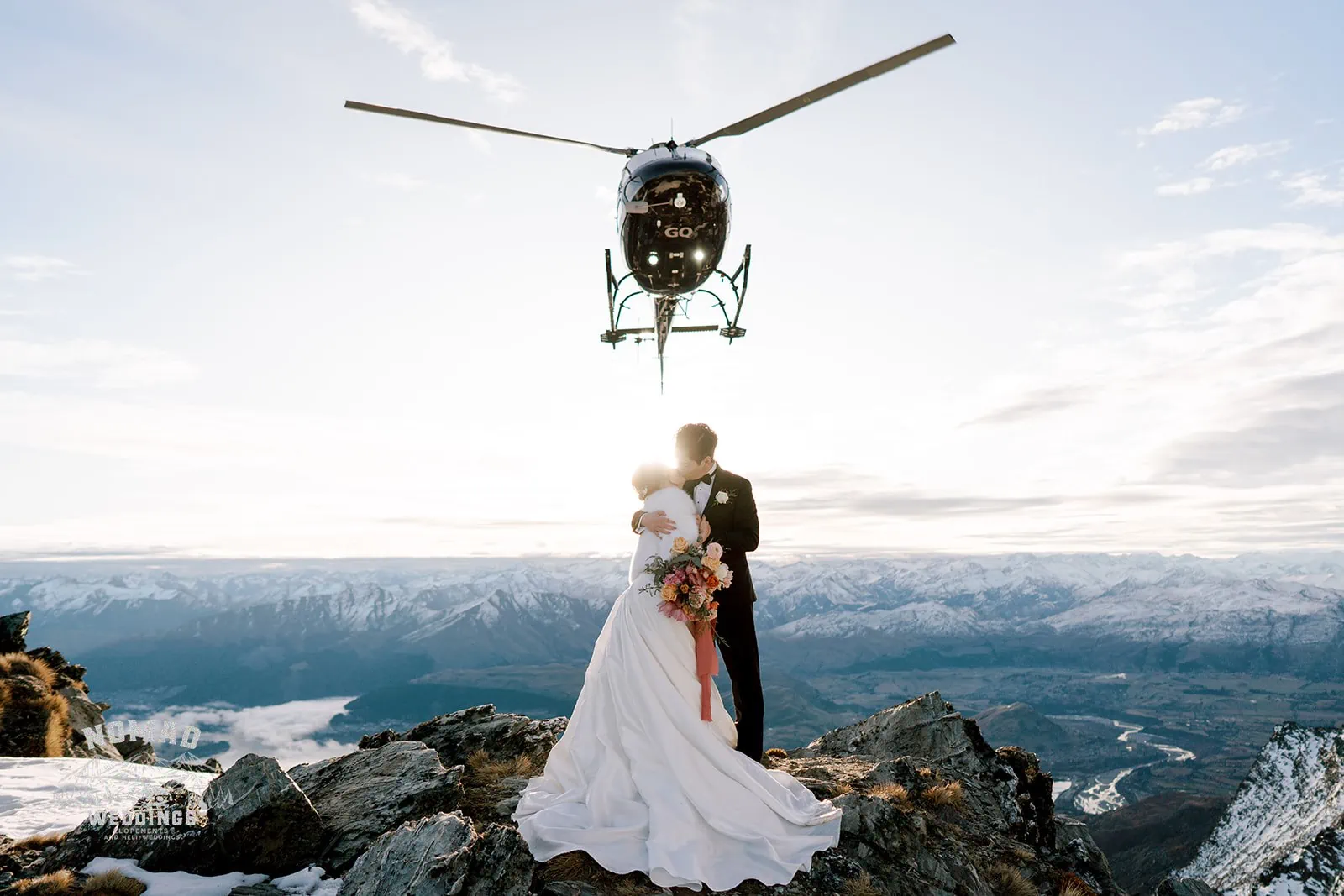 Queenstown New Zealand Elopement Wedding Photographer - Bo and Junyi, on top of a mountain, embrace their unforgettable heli pre-wedding shoot featuring 4 breathtaking landings.