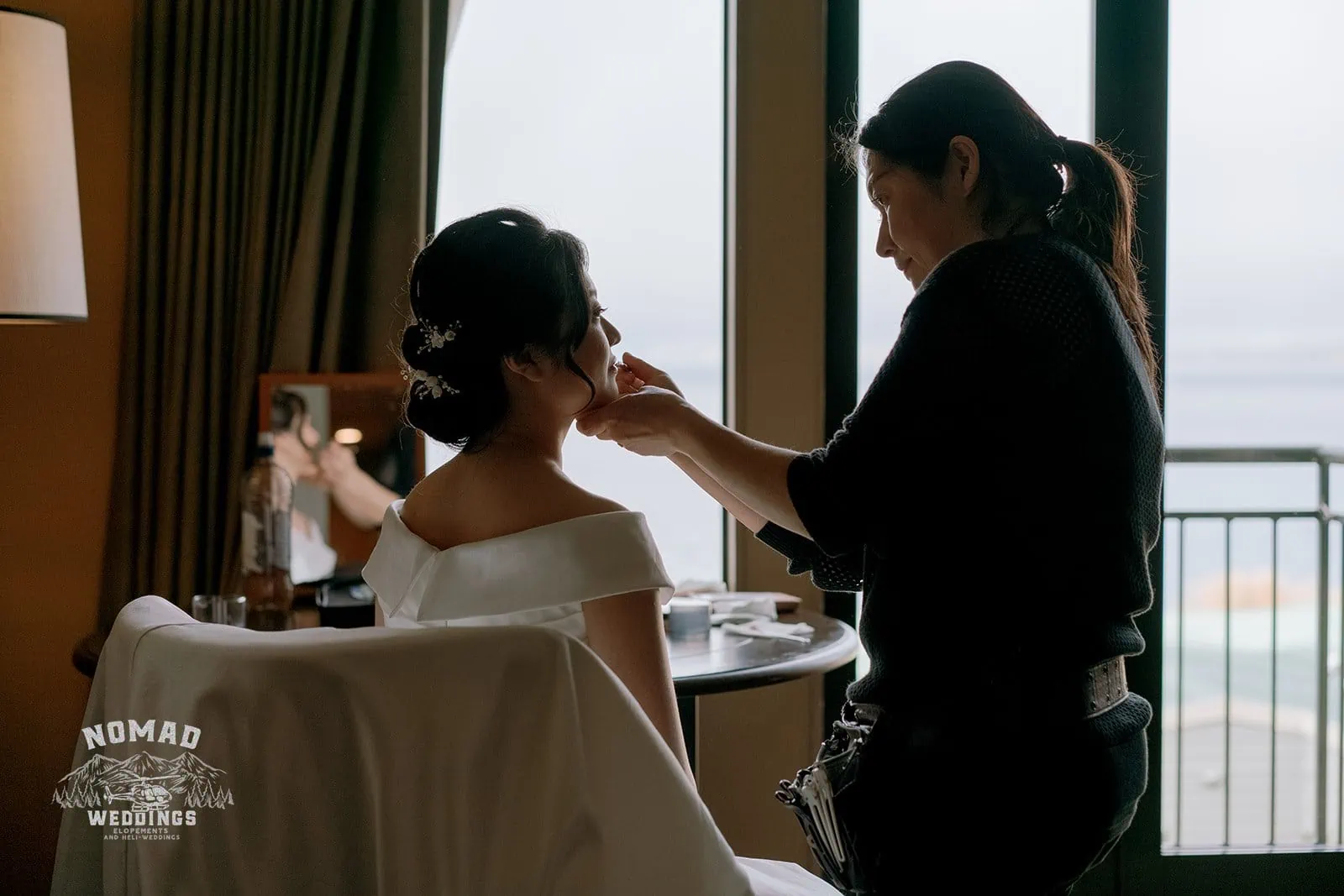 Queenstown New Zealand Elopement Wedding Photographer - A bride getting her makeup done in a hotel room for a Heli Pre Wedding Shoot with 4 Landings.