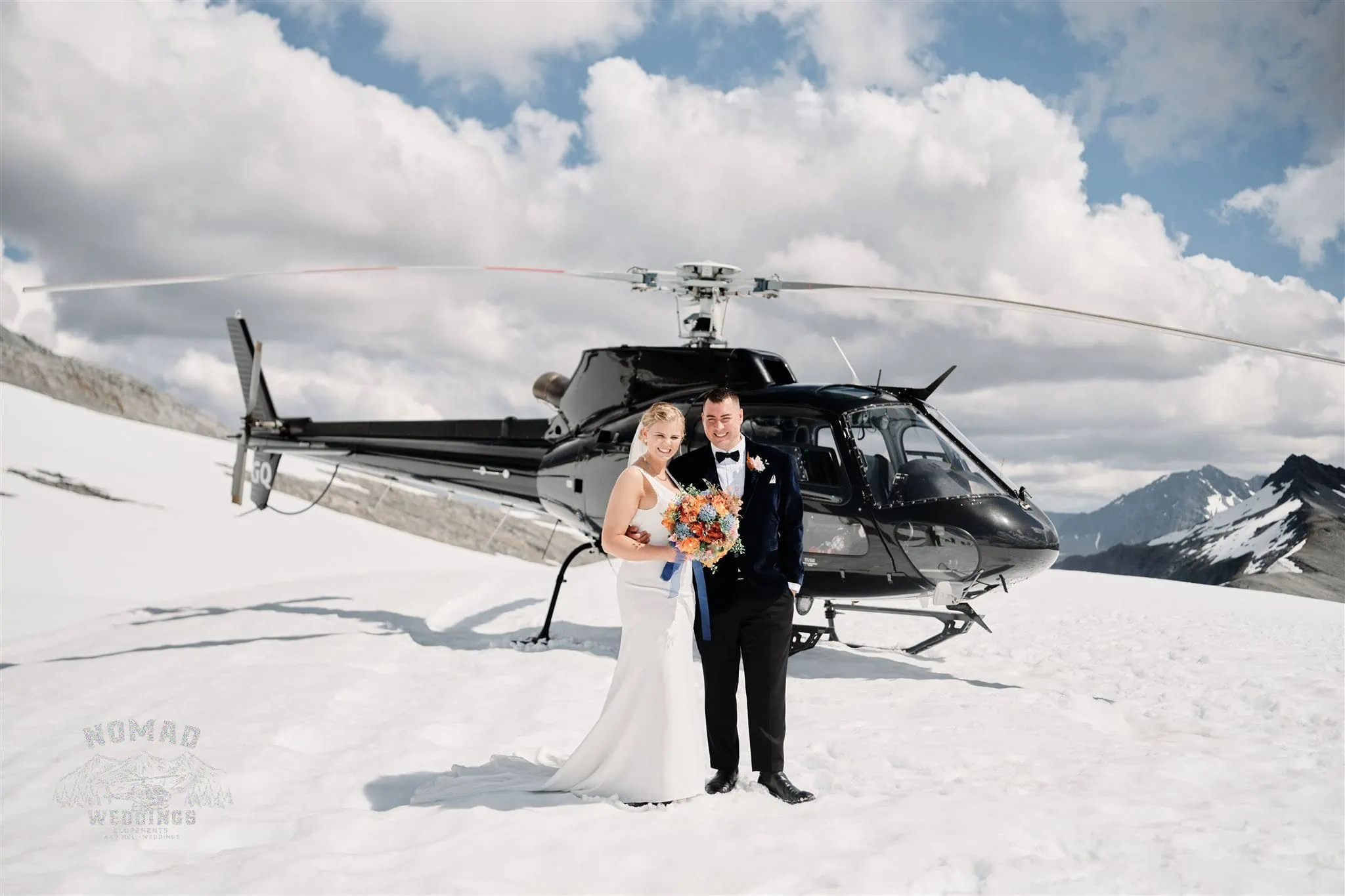 Queenstown New Zealand Elopement Wedding Photographer - A bride and groom standing in front of a helicopter during the Summer Edition - Heli photoshoot in Queenstown, NZ.