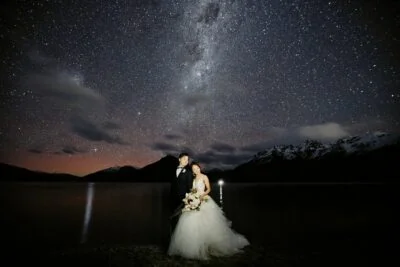 Queenstown New Zealand Elopement Wedding Photographer - A starry night shoot featuring a bride and groom standing under the milky way, showcasing the photographer's portfolio.
