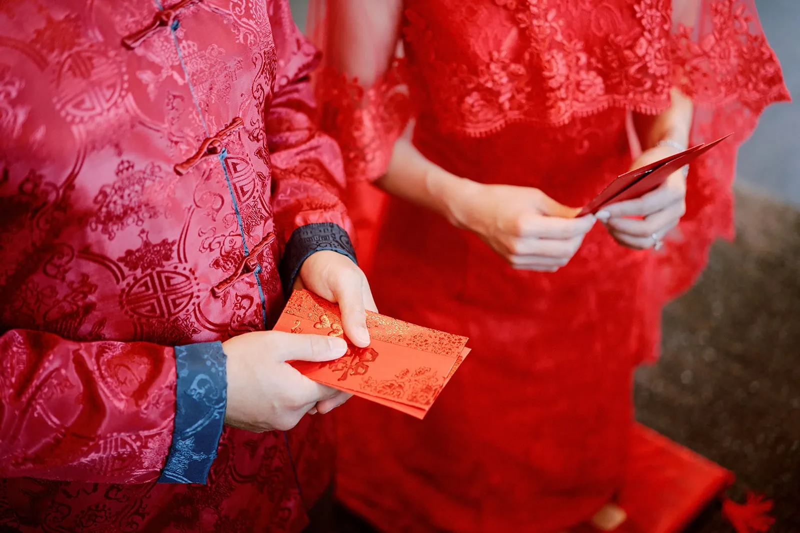 Queenstown New Zealand Elopement Wedding Photographer - A man and woman in red Chinese outfits celebrating their ultimate Queenstown elopement with red envelopes.