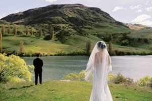 Queenstown New Zealand Elopement Wedding Photographer - Josh and his bride standing in front of a lake for their wedding portfolio shoot.