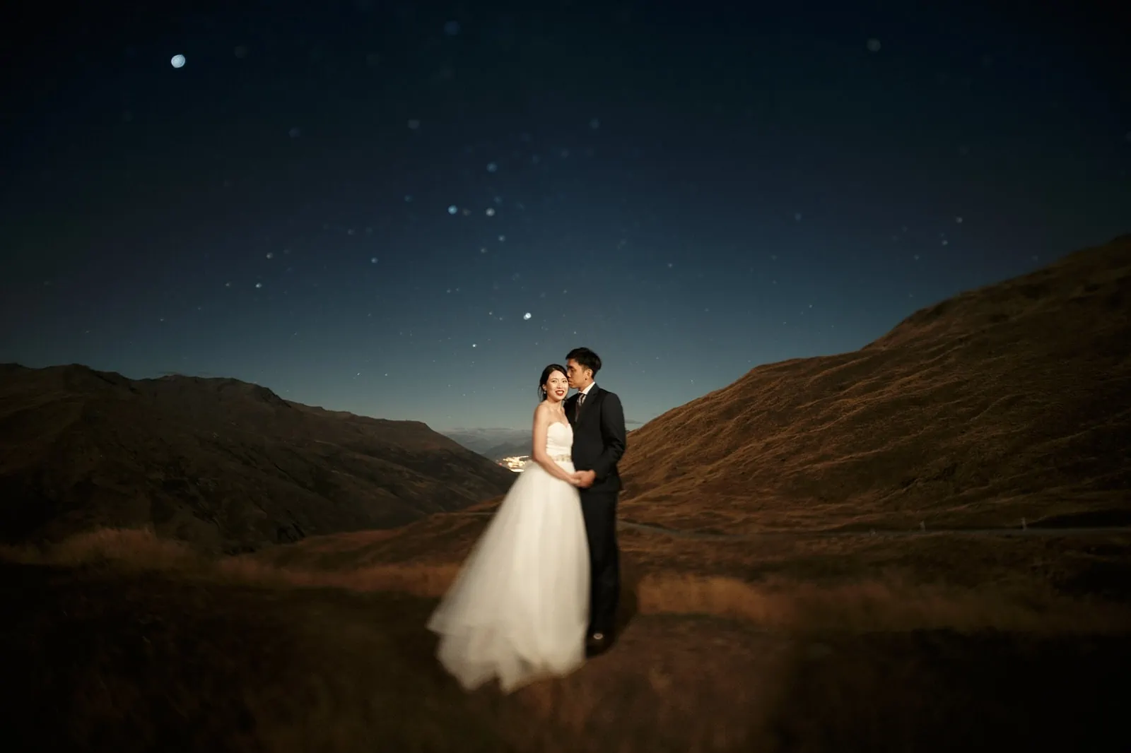 Queenstown New Zealand Elopement Wedding Photographer - A bride and groom posing for a picturesque starry night shoot, showcasing our portfolio of enchanting nighttime wedding photographs.