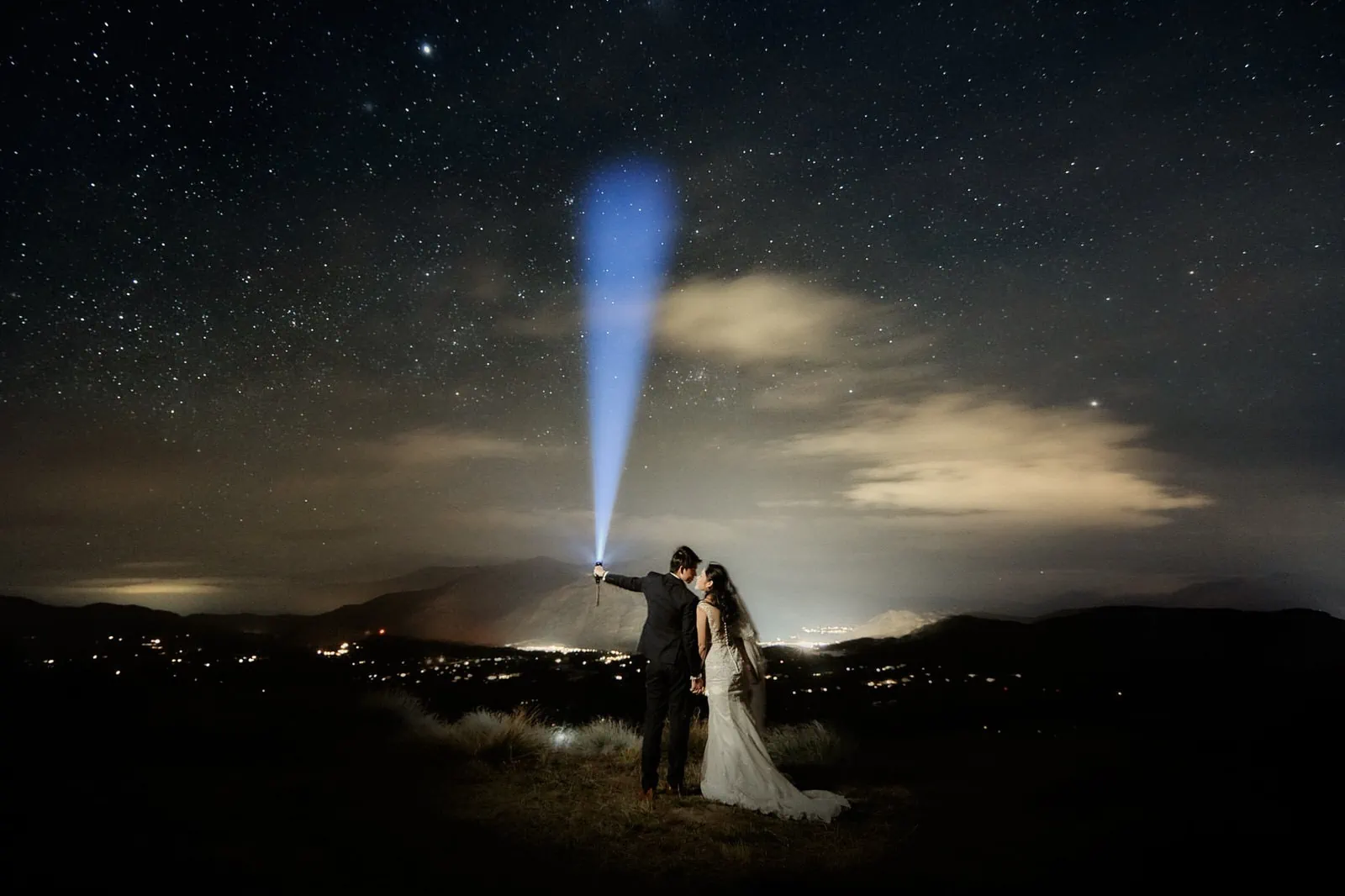 Queenstown New Zealand Elopement Wedding Photographer - A bride and groom standing on top of a hill under a starry sky, captured beautifully for our portfolio.
