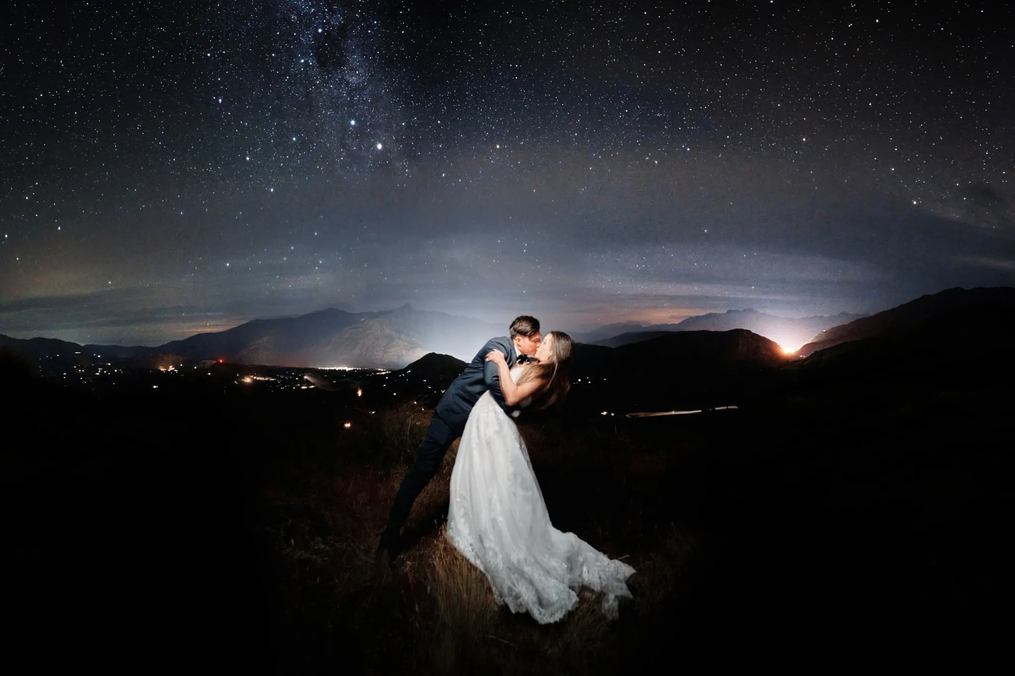 Queenstown New Zealand Elopement Wedding Photographer - A bride and groom kiss under the starry night.
