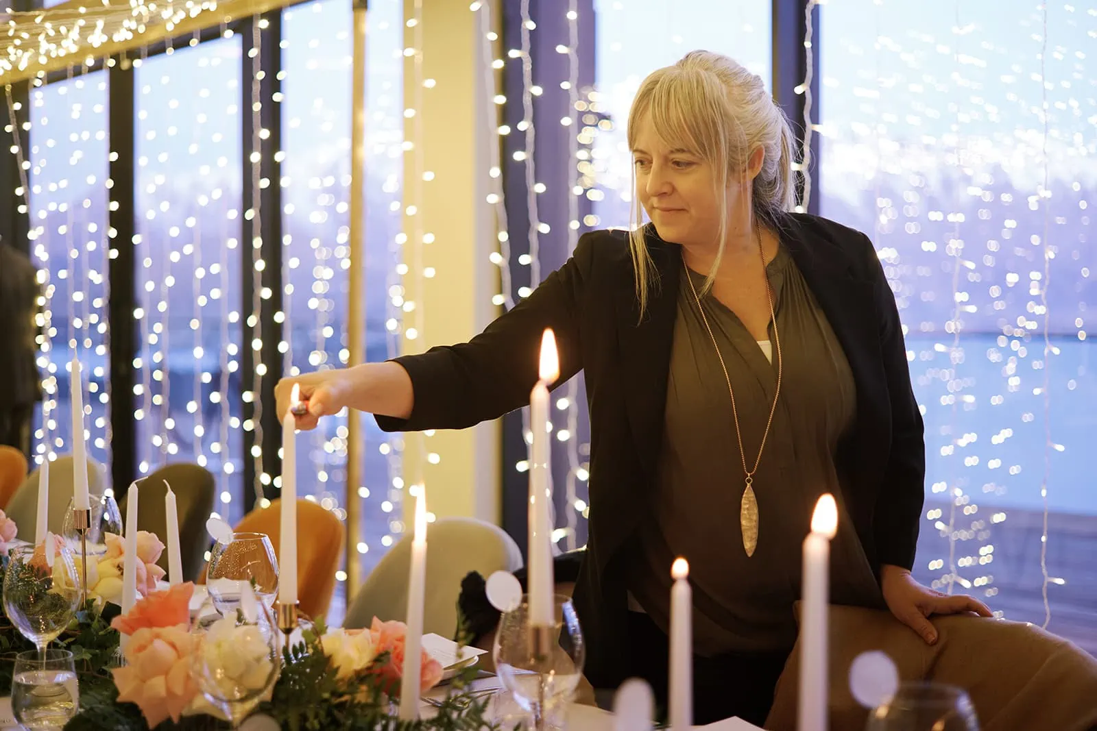 Queenstown New Zealand Elopement Wedding Photographer - A woman lighting candles at a table.
