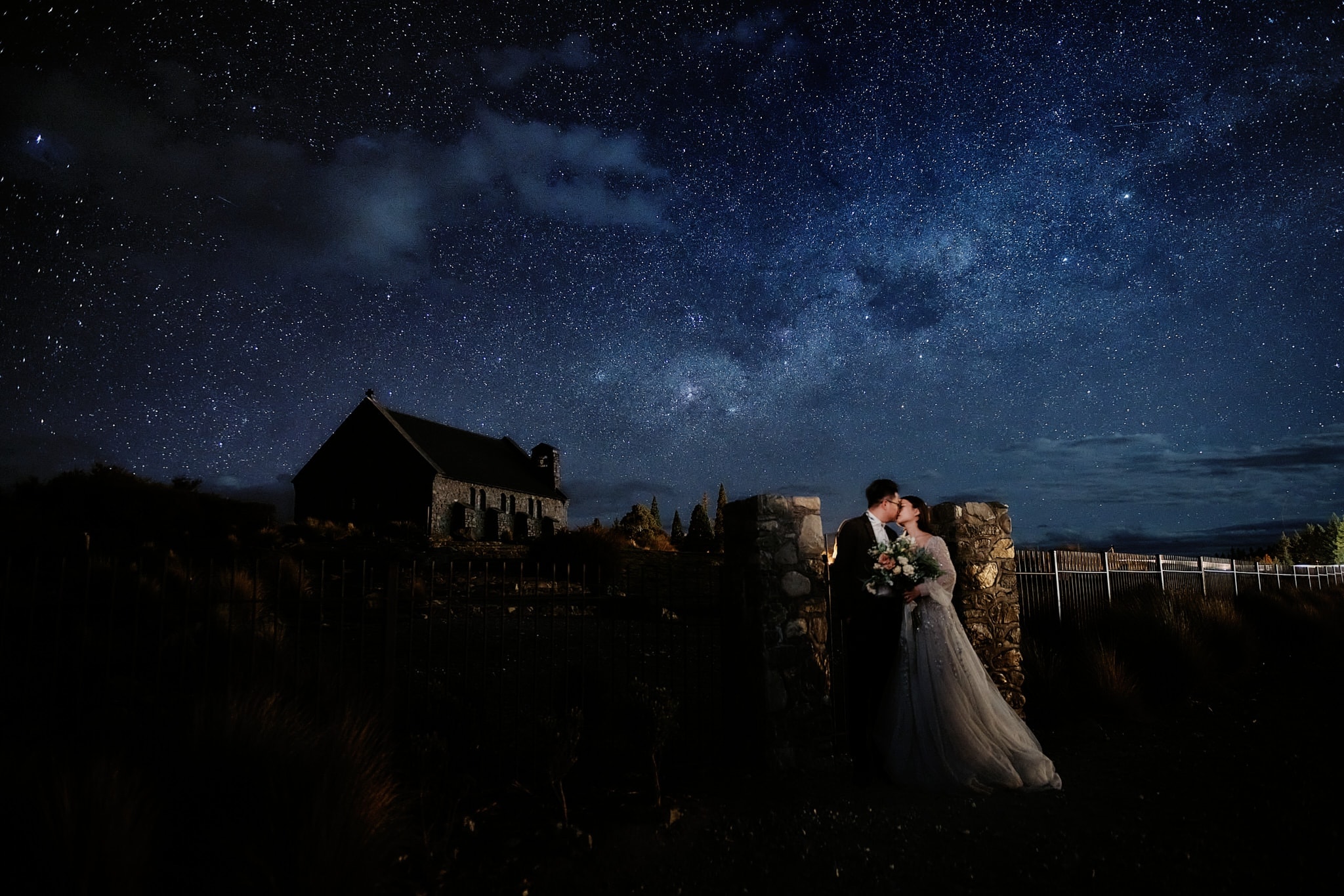 Queenstown New Zealand Elopement Wedding Photographer - A bride and groom share a passionate kiss under the starry night at their wedding in New Zealand, creating a captivating moment for their portfolio.