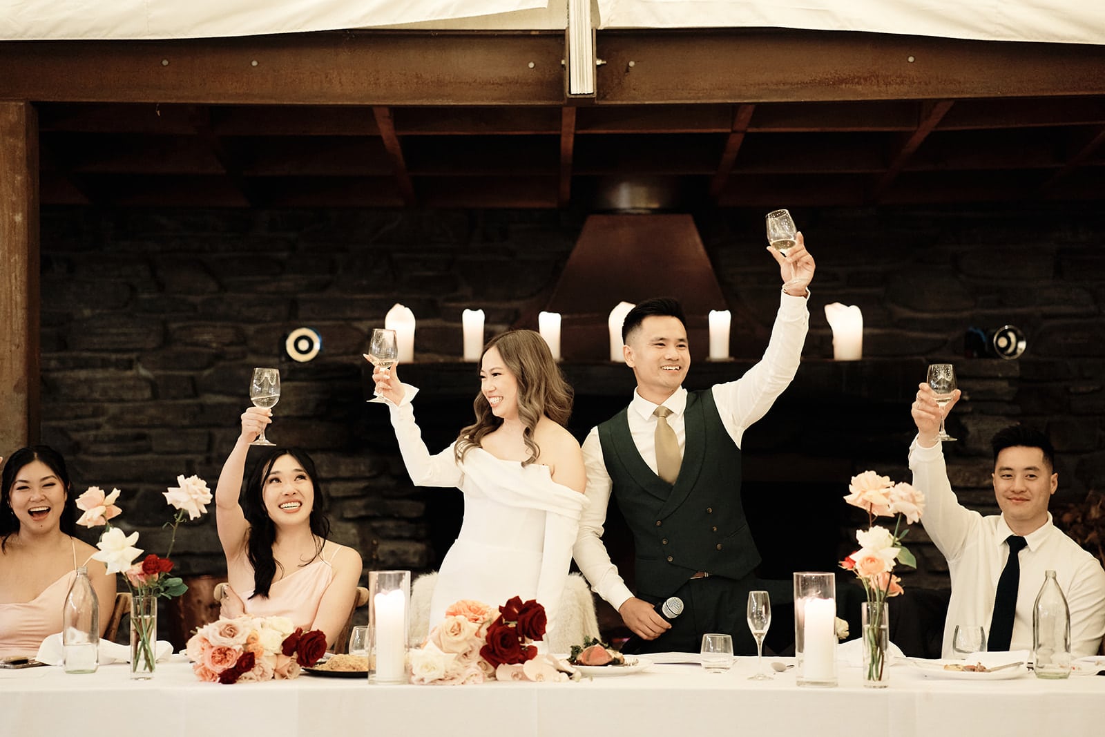 Queenstown New Zealand Elopement Wedding Photographer - Lindy and Tom, a couple in an intimate elopement wedding, raising their glasses at a table.