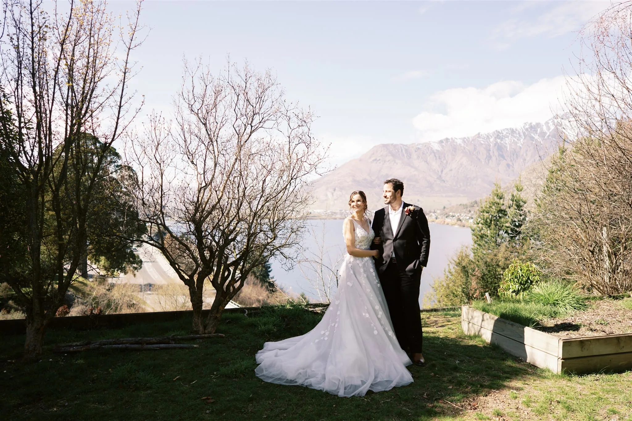 Queenstown New Zealand Elopement Wedding Photographer - A bride and groom, Alex & Shahar, posing in front of a lake during their Queenstown elopement.