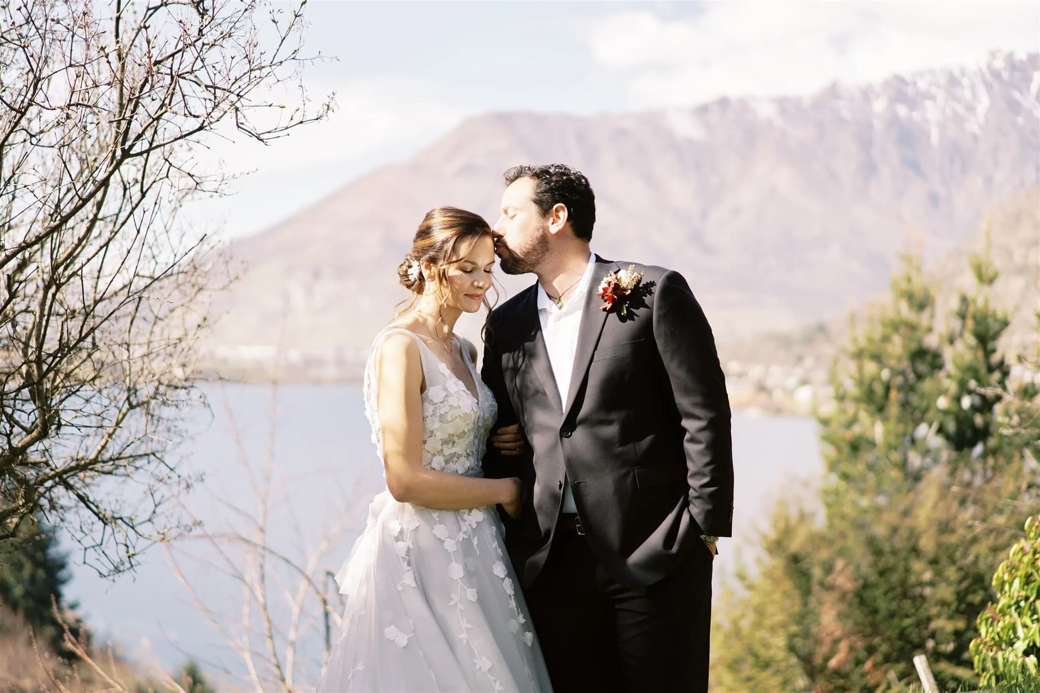 Queenstown New Zealand Elopement Wedding Photographer - Queenstown bride and groom standing in front of a lake with mountains in the background.