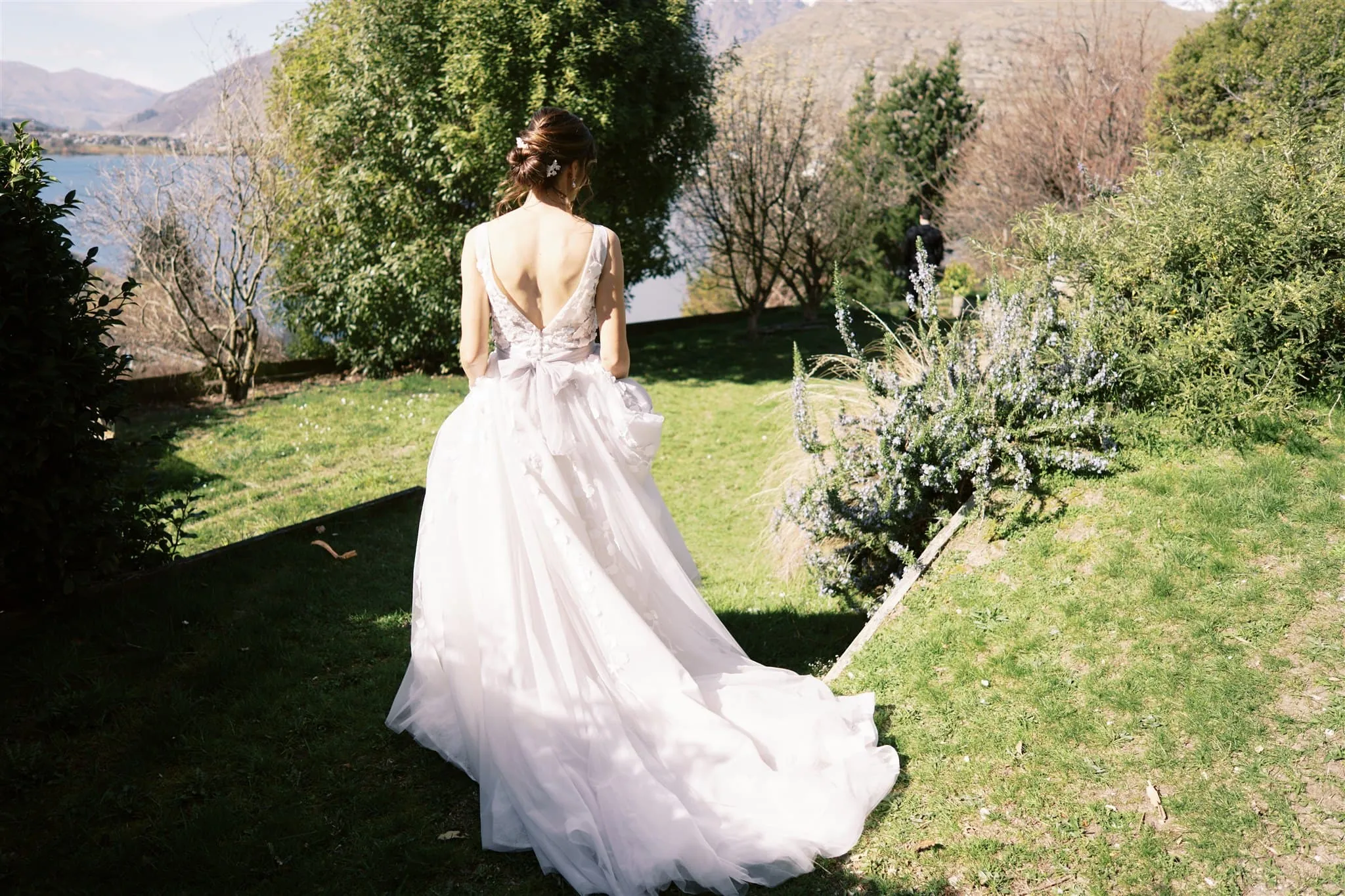 Queenstown New Zealand Elopement Wedding Photographer - A bride in a wedding dress walks down a grassy path during her Queenstown elopement.