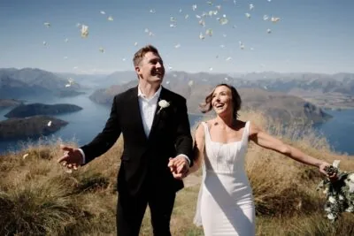 Queenstown New Zealand Elopement Wedding Photographer - A bride and groom standing on top of a mountain during their queenstown heli-wedding.