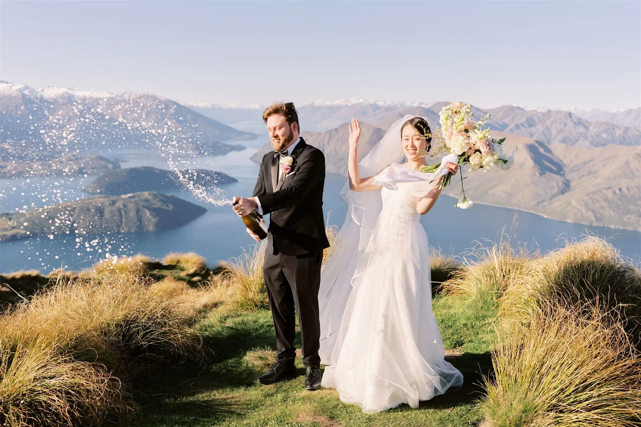 Queenstown New Zealand Elopement Wedding Photographer - A bride and groom celebrating their wedding on top of a mountain in Queenstown, New Zealand with the heli-wedding package.