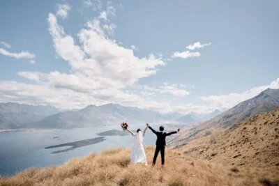 Queenstown New Zealand Elopement Wedding Photographer - A bride and groom standing on top of Mt Creighton, overlooking Lake Wakatipu