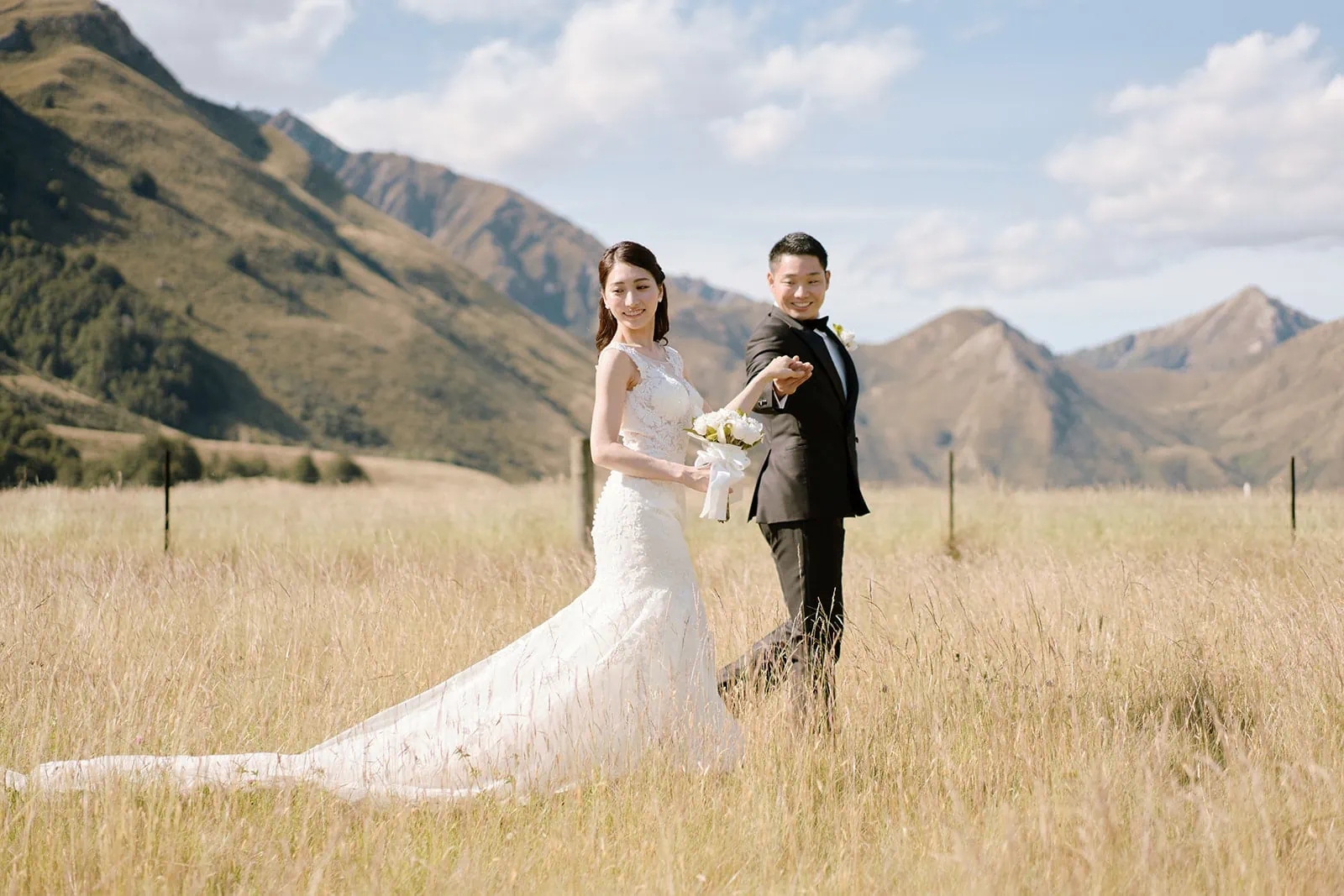 Queenstown Elopement Heli Wedding Photographer クイーンズタウン結婚式 | A man and woman in a field for their pre-wedding shoot.