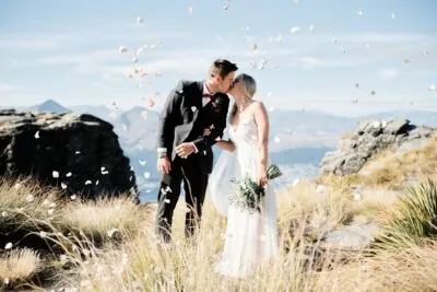 Queenstown New Zealand Elopement Wedding Photographer - A bride and groom kissing on top of Cecil Peak, a majestic mountain in New Zealand.