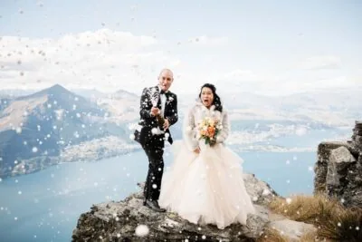 Queenstown New Zealand Elopement Wedding Photographer - Bride and groom throwing confetti on top of Cecil Peak in Queenstown, New Zealand.