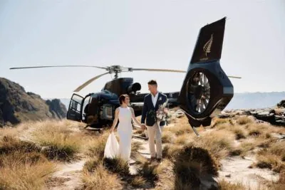 Queenstown New Zealand Elopement Wedding Photographer - A bride and groom standing in front of a helicopter at Cecil Peak.