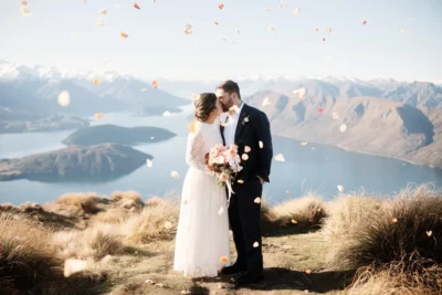 Queenstown New Zealand Elopement Wedding Photographer - On Coromandel Peak, a mountain in New Zealand, a bride and groom share a tender kiss while overlooking Lake Wanaka.