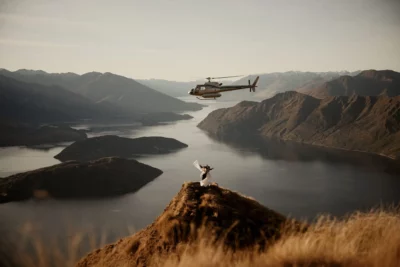 Queenstown New Zealand Elopement Wedding Photographer - A helicopter is flying over Coromandel Peak with a couple on top of it.