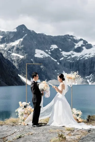 Queenstown New Zealand Elopement Wedding Photographer - A Erskine bride and groom standing in front of a Lake with mountains in the background.