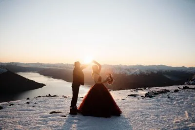 Queenstown New Zealand Elopement Wedding Photographer - A bride and groom standing on top of the Remarkables, a snowy mountain at sunset.