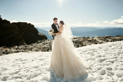 Queenstown New Zealand Elopement Wedding Photographer - A bride and groom standing on top of The Remarkables, a snow covered mountain.