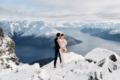 Queenstown New Zealand Elopement Wedding Photographer - A bride and groom standing on top of the Remarkables, a snowy mountain in Queenstown, New Zealand.