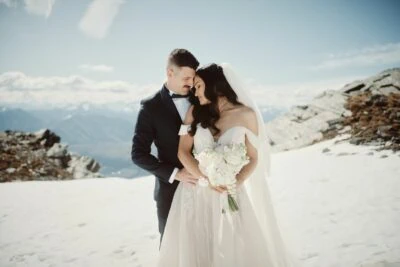 Queenstown New Zealand Elopement Wedding Photographer - A bride and groom embracing on top of a snowy mountain adorned with Remarkables.