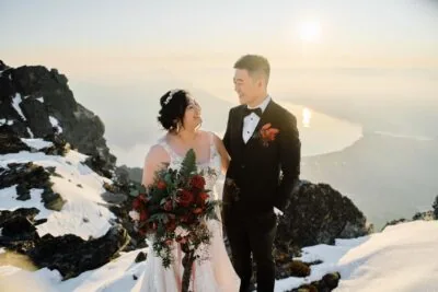 Queenstown New Zealand Elopement Wedding Photographer - A bride and groom enjoying their wedding ceremony atop a Remarkables mountain, surrounded by breathtaking snow-covered scenery.