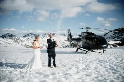 Queenstown New Zealand Elopement Wedding Photographer - A bride and groom standing in front of a helicopter at The Remarkables.