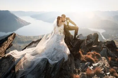 Queenstown New Zealand Elopement Wedding Photographer -     Description: A bride and groom standing atop the Remarkables, with breathtaking views of Lake Wanaka.