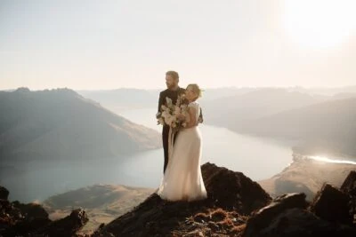 Queenstown New Zealand Elopement Wedding Photographer - Bride and groom enjoying the remarkable views from the top of a mountain overlooking Lake Wanaka.