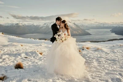 Queenstown New Zealand Elopement Wedding Photographer - A bride and groom standing on top of the Remarkables, a snow covered mountain in Queenstown, New Zealand.
