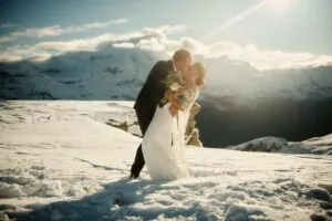 Queenstown New Zealand Elopement Wedding Photographer - A bride and groom kissing on top of Tyndall Glacier, a snow covered mountain.