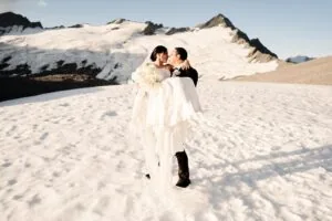 Queenstown New Zealand Elopement Wedding Photographer - A bride and groom standing on top of Tyndall Glacier, a snow covered mountain.