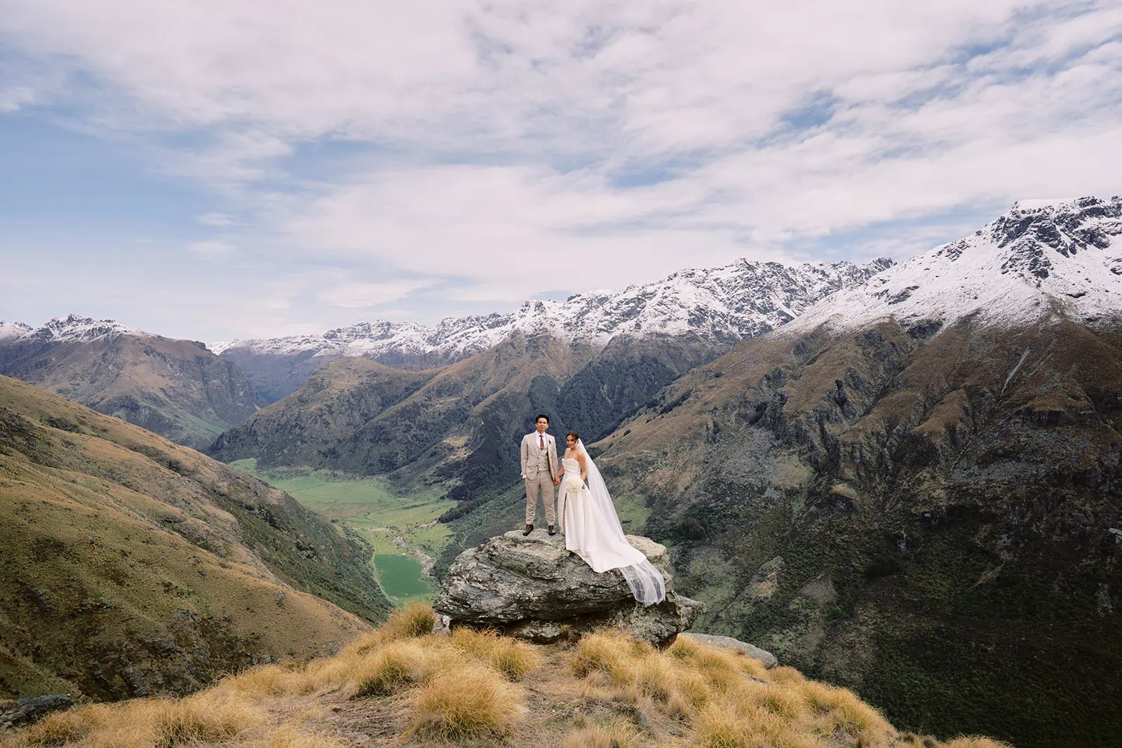Queenstown Elopement Heli Wedding Photographer クイーンズタウン結婚式 | Tobi and Ceidi, a bride and groom, standing on top of a mountain in Queenstown, New Zealand.