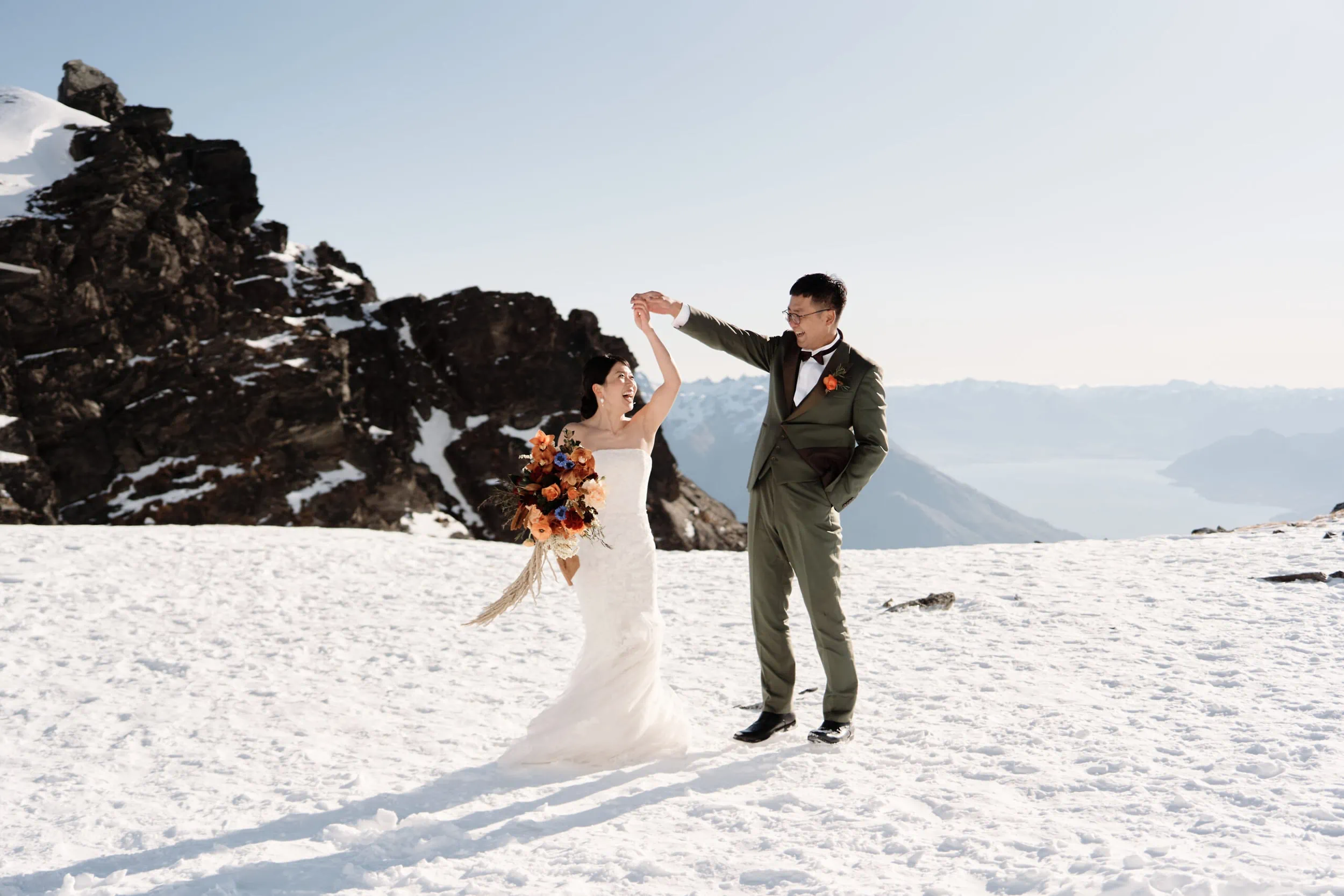 Queenstown Wedding Photographer A bride and groom dancing on top of a snow covered mountain in Queenstown Heli.