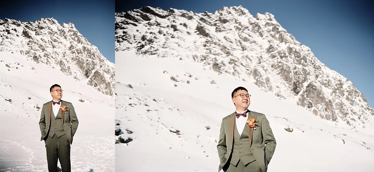 Queenstown Wedding Photographer A man in a suit standing in front of a snowy mountain during their Queenstown Heli Pre Wedding Shoot.