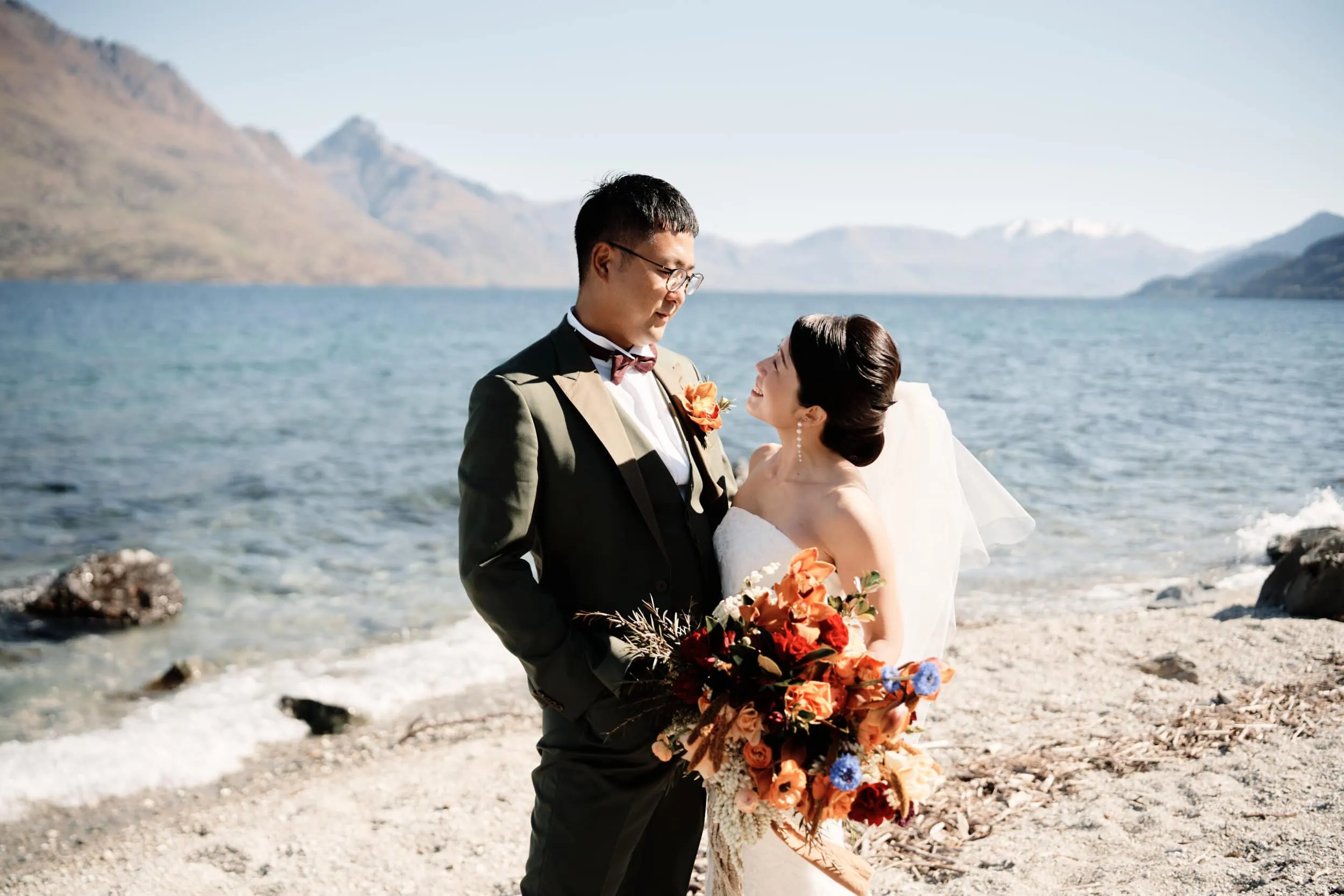 Queenstown Wedding Photographer A pre-wedding couple standing on the shore of Lake Wanaka.