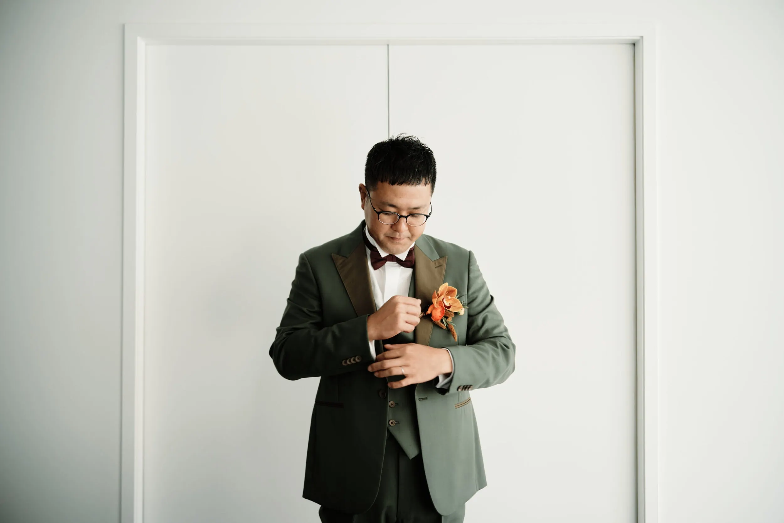 Queenstown Wedding Photographer A man in a green suit is adjusting his tie during a Pre Wedding Shoot in Queenstown.