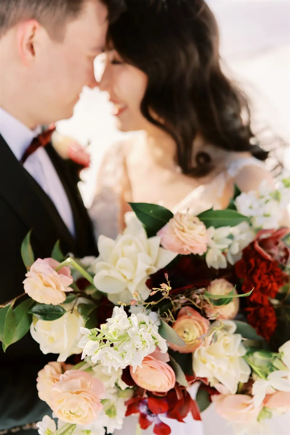 Queenstown Elopement Heli Wedding Photographer クイーンズタウン結婚式 | An elopement wedding of a bride and groom holding a bouquet in the snow.