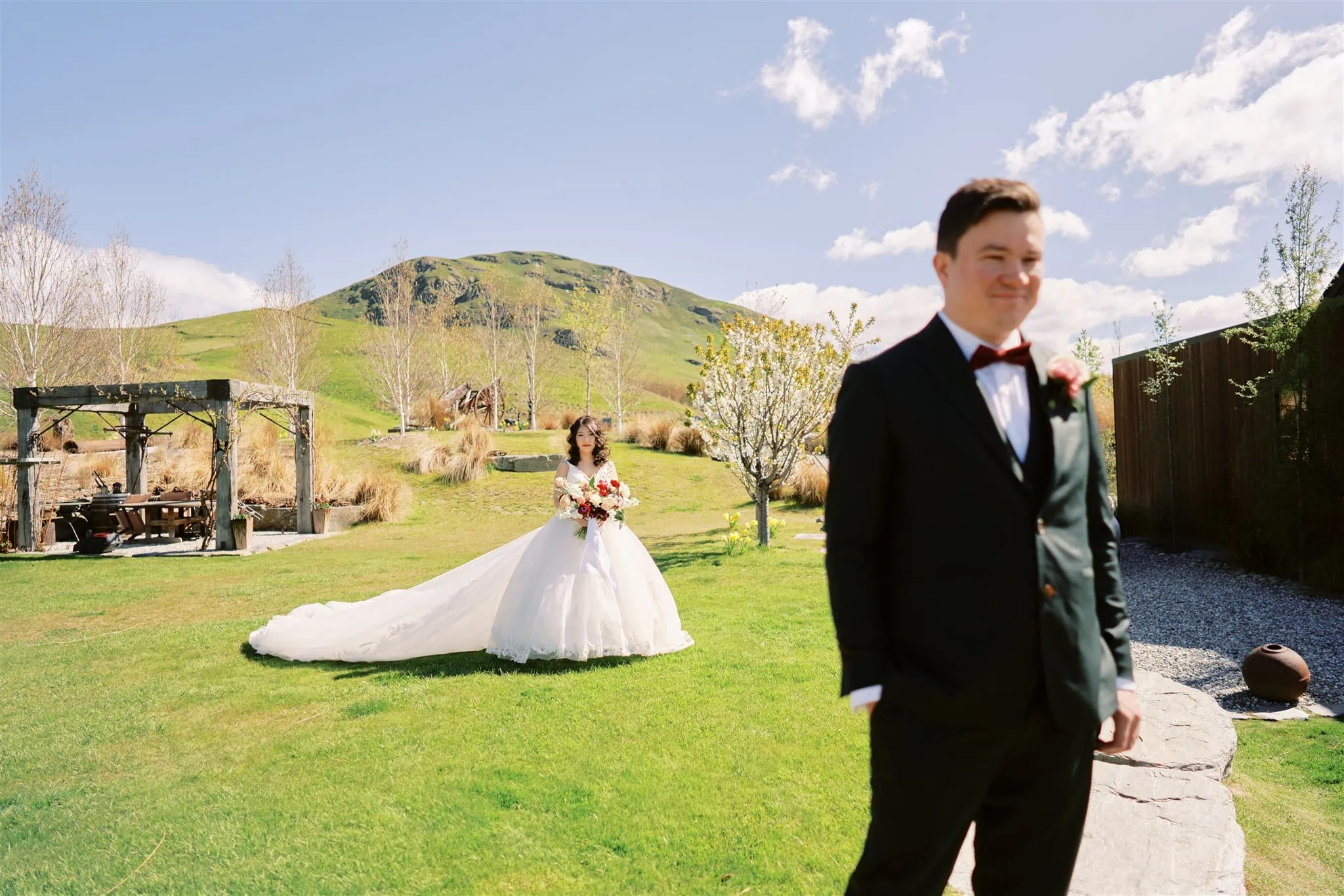 Queenstown Elopement Heli Wedding Photographer クイーンズタウン結婚式 | Michael and Alex, the bride and groom, standing in a grassy area near Roy's Peak.