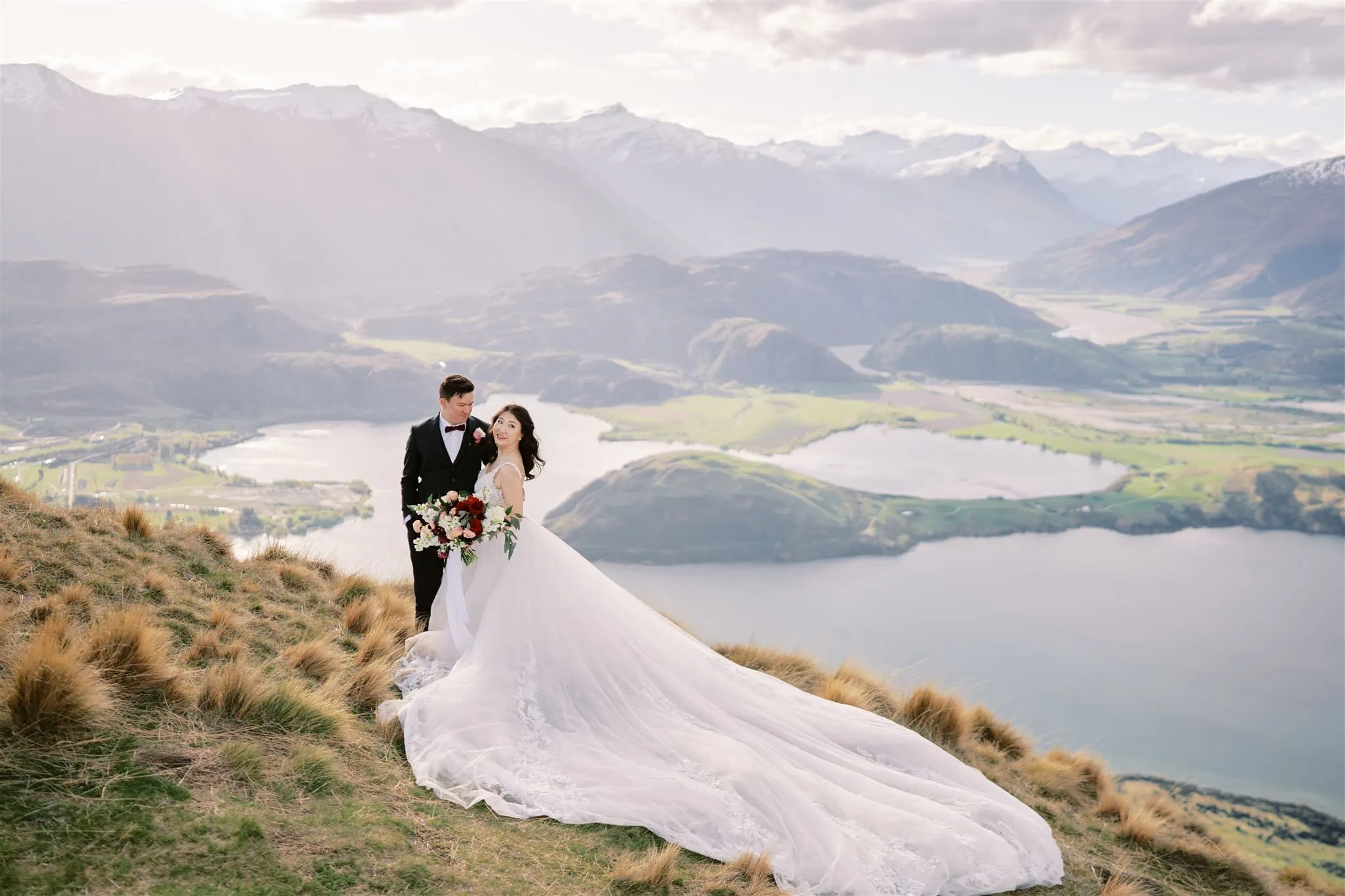 Queenstown Elopement Heli Wedding Photographer クイーンズタウン結婚式 | Elopement wedding couple standing on top of a hill overlooking Lake Wanaka.