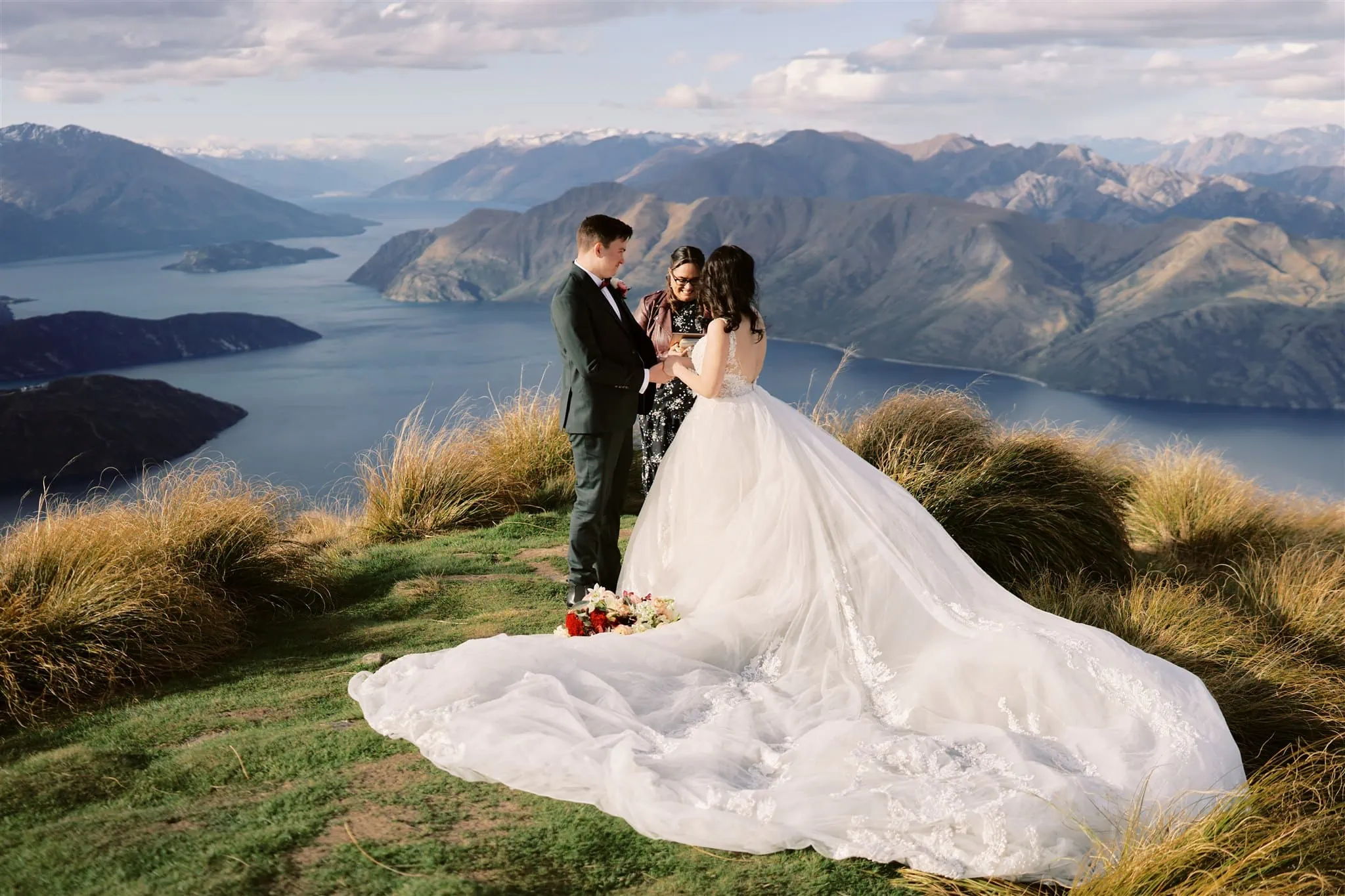 Queenstown Elopement Heli Wedding Photographer クイーンズタウン結婚式 | An elopement wedding with a bride and groom standing on top of a mountain overlooking Lake Wanaka.