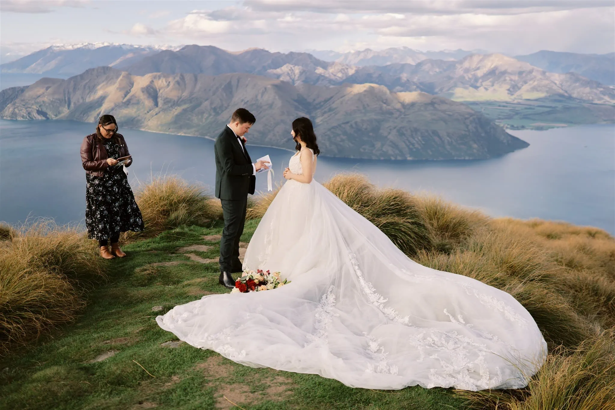 Queenstown Elopement Heli Wedding Photographer クイーンズタウン結婚式 | An elopement wedding couple standing on top of a mountain overlooking Lake Wanaka.