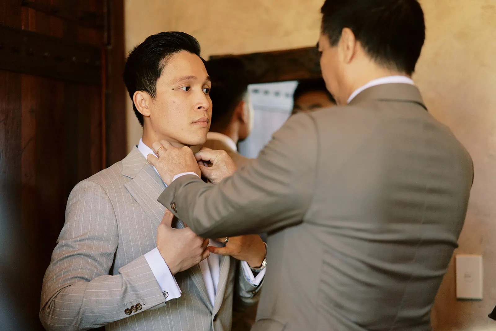 Queenstown Elopement Heli Wedding Photographer クイーンズタウン結婚式 | Tobi, dressed in a suit, is adjusting his tie.
